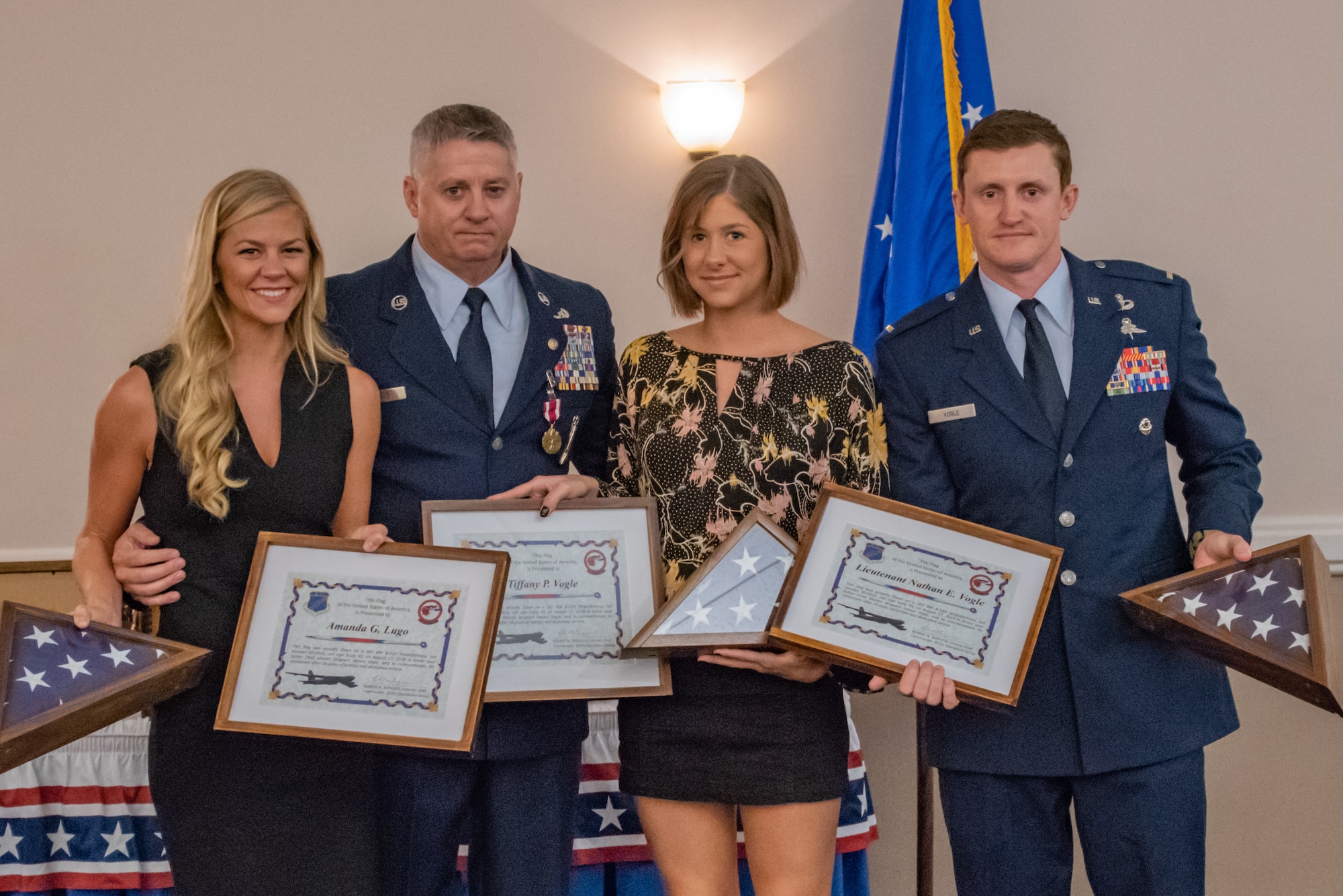 Retired Chief Master Sgt. Steven Vogle presents his children with certificates and flags during his retirement ceremony at Barksdale Air Force base, La, Sept. 8, 2018. The presents were given as a token of Vogle's appreciation to his family for the support that they have shown over his 34 years of service. (U.S. Air Force photo by Tech. Sgt. Cody Burt/Released)