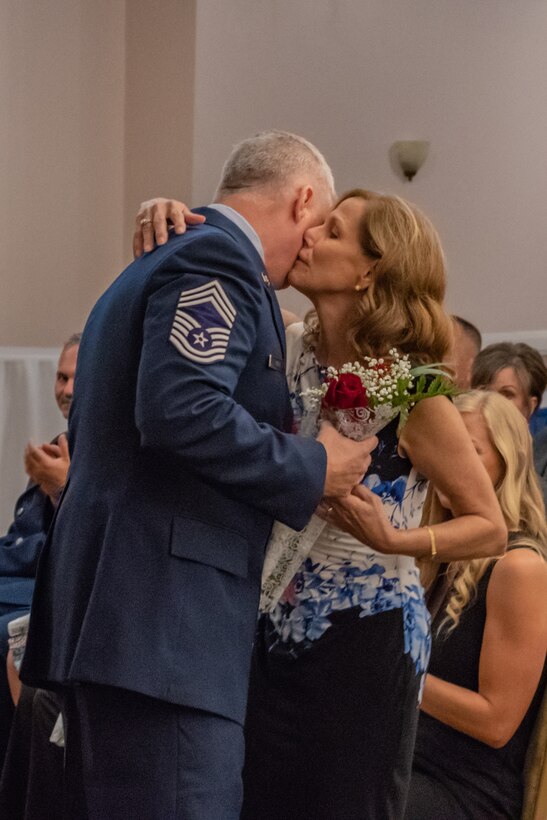 Retired Chief Master Sgt. Steven Vogle presents his wife, Karen, with flowers during his retirement ceremony at Barksdale Air Force base, La, Sept. 8, 2018. Vogle gave his wife the flowers in appreciation for her support. (U.S. Air Force photo by Tech. Sgt. Cody Burt/Released)