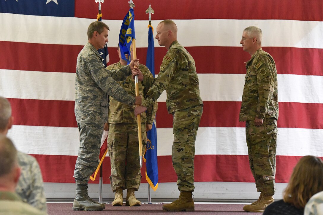 Col. Darrin Anderson, the 119th Wing commander, left, presents the 219th Security Forces Squadron unit flag guidon to Maj. Greg Goodman as Goodman assumes command in a symbolic gesture with the flag representing the squadron command of the 219th Security Forces Squadron at the Minot Air Force Base, N.D., Sept. 8, 2018.