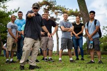 Chris Majewski, a tour guide, points to a Japanese offensive position during a tour Sept. 7, 2018 at Hacksaw Ridge, Okinawa, Japan. Marines and Sailors with Headquarters Company, Headquarters Regiment, 3rd Marine Logistics Group, participated in the World War II battle site tour to learn about the U.S. Marine Corps’ history on Okinawa and remember those who have gone before them. Majewski is a tour guide with Marine Corps Community Services Tours+ and is a native of Boulder City, Nevada. (U.S. Marine Corps photo by Pfc. Terry Wong)