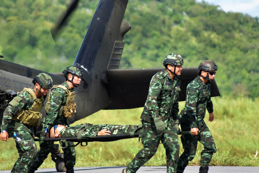 Royal Thai army rangers unload a role-playing casualty from a helicopter.