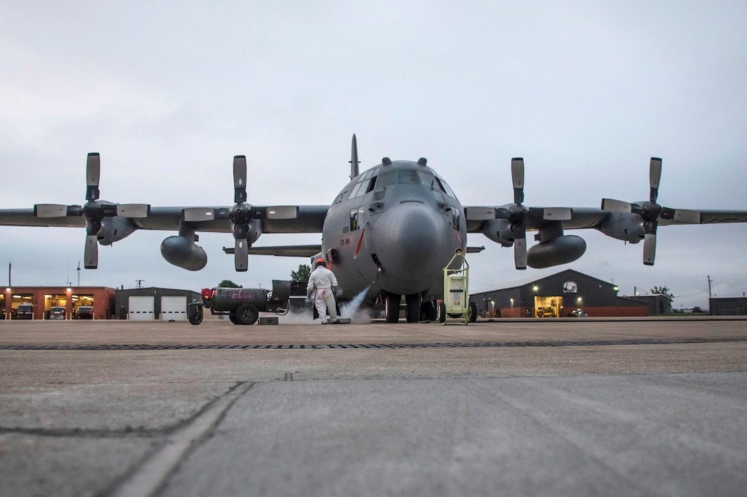 An airman watches as an aircraft is being refilled with liquid oxygen