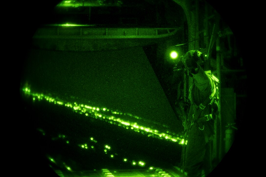 A U.S. Air Force loadmaster assigned to the 37th Airlift Squadron signals “all clear” after dropping a container delivery system from a C-130J Super Hercules over Romania, Aug. 28, 2018. The night operation was part of Carpathian Summer 2018, a bilateral training exercise designed to enhance interoperability and readiness of forces by conducting combined air operations with the Romanian air force. (U.S. Air Force photo by Senior Airman Devin Boyer)