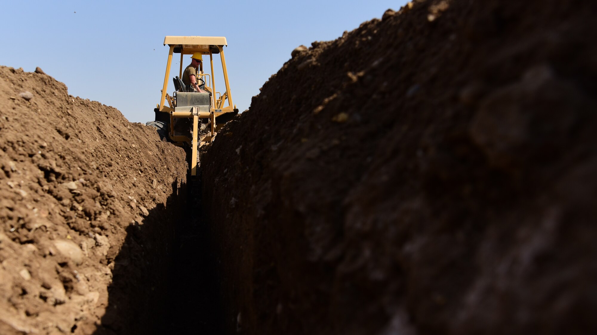 U.S. Air Force Tech. Sgt. Doug Haveman, Air Force Engineering and Installation, Iraq team chief, digs a trench Aug. 28, 2018, at Camp Taji, Iraq. Haveman manages a team of engineers who help create the network systems throughout the Combined Task Force – Operation Inherent Resolve Area of Responsibility. (U.S. Air Force photo by Staff Sgt. Christopher Stoltz)