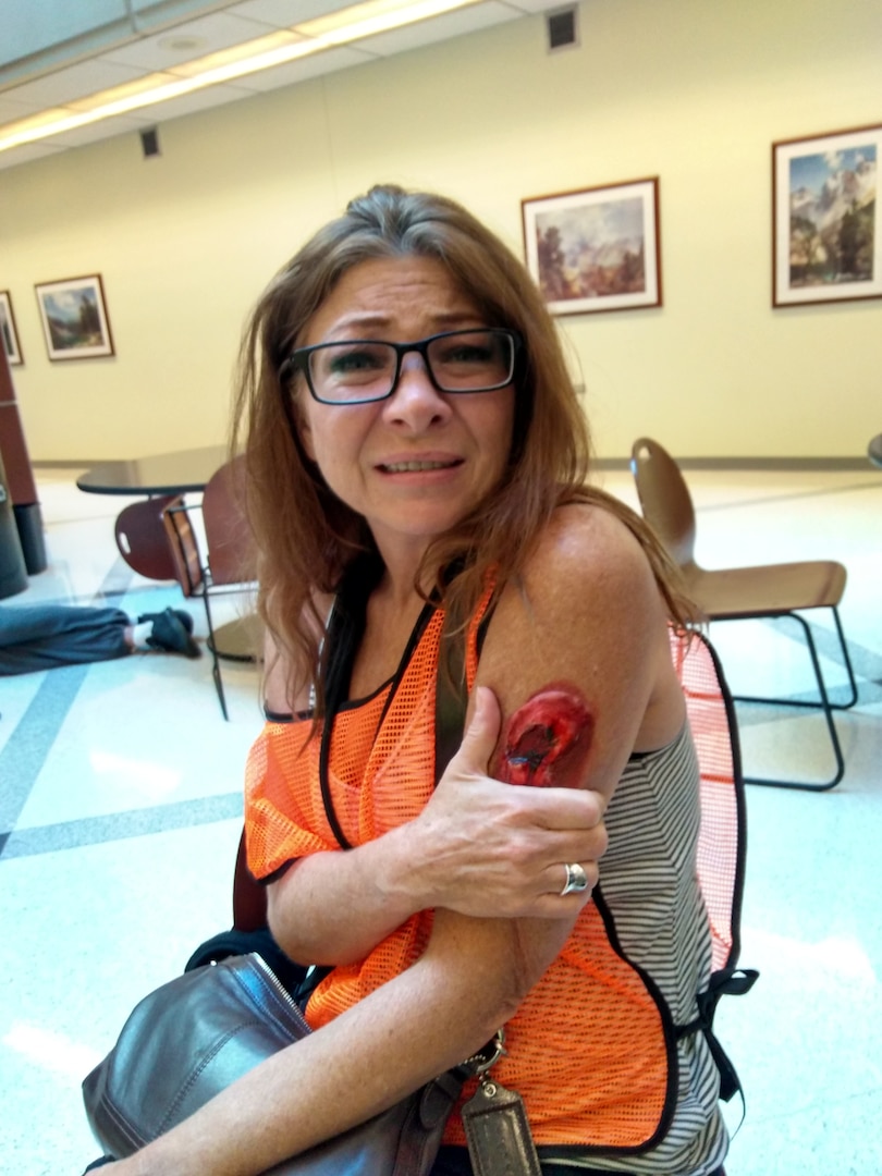 Woman clutching fake wound