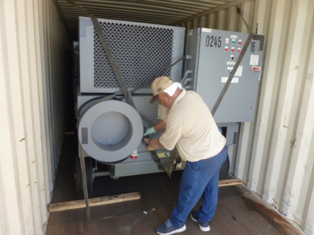 DLA Disposition Services employees ensure carts are secure inside shipping containers for a safer shipment.