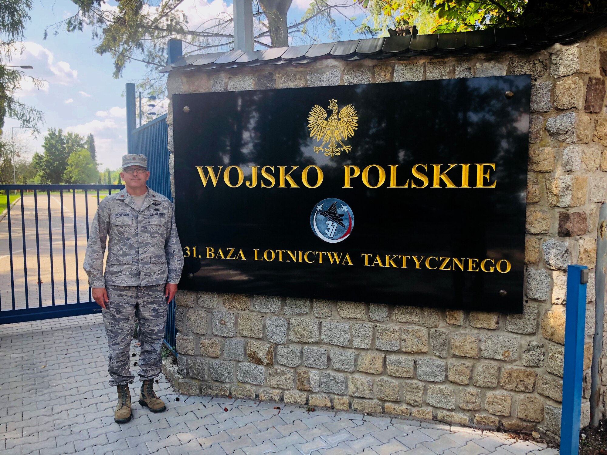 U.S. Air Force Maj. John C. Thompson, 145th Mission Support Group, poses in front of the 31st Tactical Air Base sign during the Deployable Air Base System exercise in Poznan-Krzesiny, Poland, July 30, 2018. Major Thompson spent the majority of July and August in Poland as the exercise commander of the new Deployable Air Base System. It is new concept for the U.S. Air Force and enables the military to respond to potential contingency needs more rapidly.enables the military to respond to potential contingency needs more rapidly.