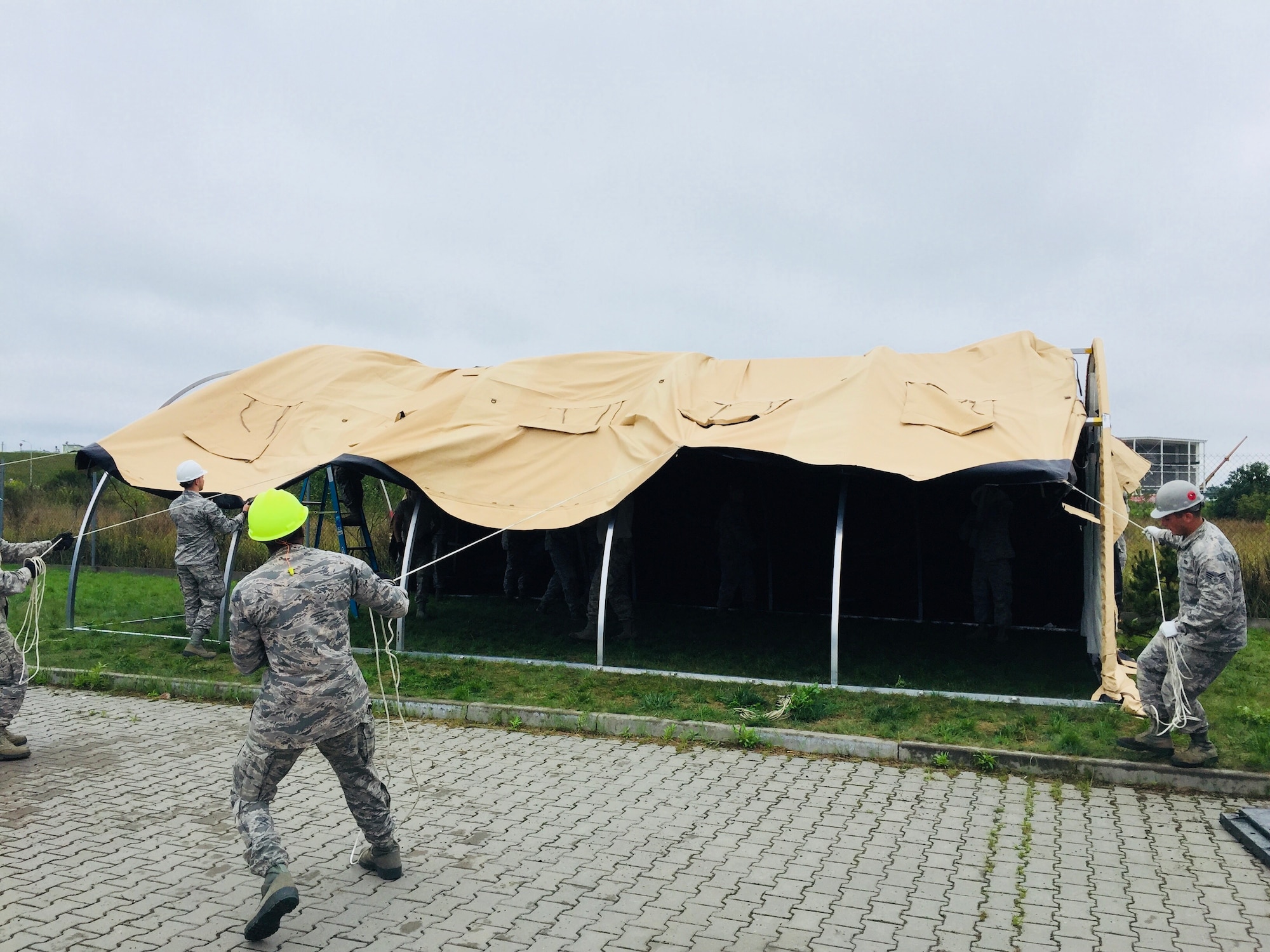 Airmen work together to setup tent city during the Deployable Air Base System (DAPS) exercise at the 31st Tactical Air Base in Poznan-Krzesiny, Poland, July 30, 2018. The DAPS exercise is a new concept for the U.S. Air Force and includes facilities, equipment, and vehicles as part of the setup to support a deployable airbase. This enables the military to respond to potential contingency needs more rapidly.