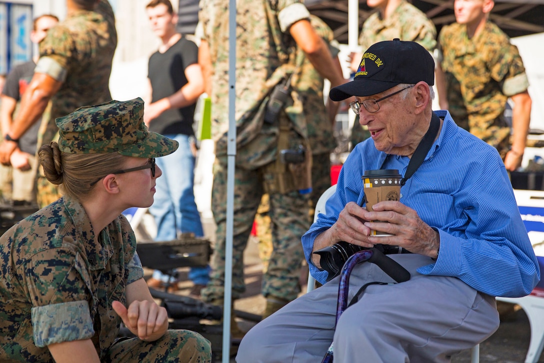 A Marine speaks with a World War II veteran.