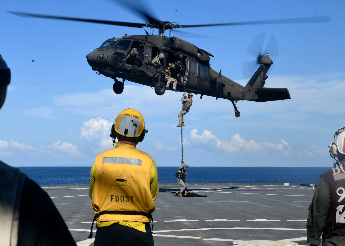 U.S. and Colombian forces conduct fast rope exercises from an Army UH-60L helicopter aboard USS Gunston Hall.