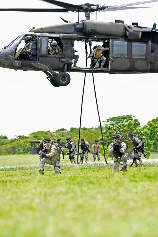 U.S. and Colombian forces conduct fast rope exercises from an Army UH-60L helicopter.