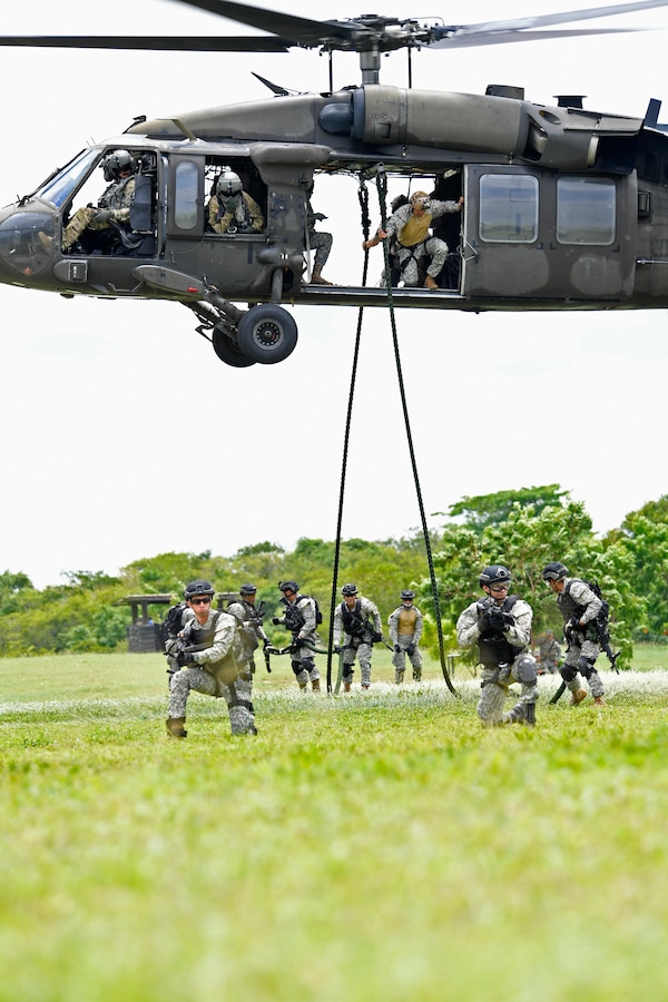 U.S. and Colombian forces conduct fast rope exercises from an Army UH-60L helicopter.