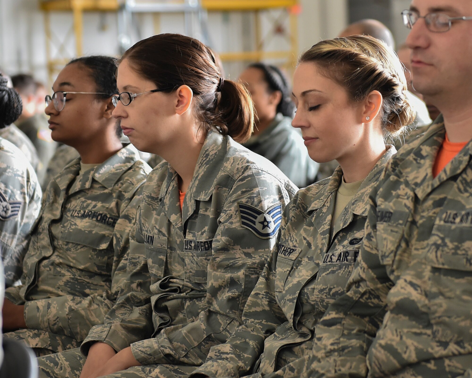 910th Airlift Wing Reserve Citizen Airmen take a “mindful minute” during a commanders call with Dr. Janelle MacAulay in Hangar 295, Youngstown Air Reserve Station, September 8, 2018. MacAulay is a wellness educator, yoga instructor, mindfulness researcher, and holds a certificate in plant based nutrition. She specializes in improving the performance of the members of high-stress organizations through a focus on nutrition, physical and mental fitness, human connection, and values discovery. (U.S. Air Force photo/Staff Sgt. Jeffrey Grossi)