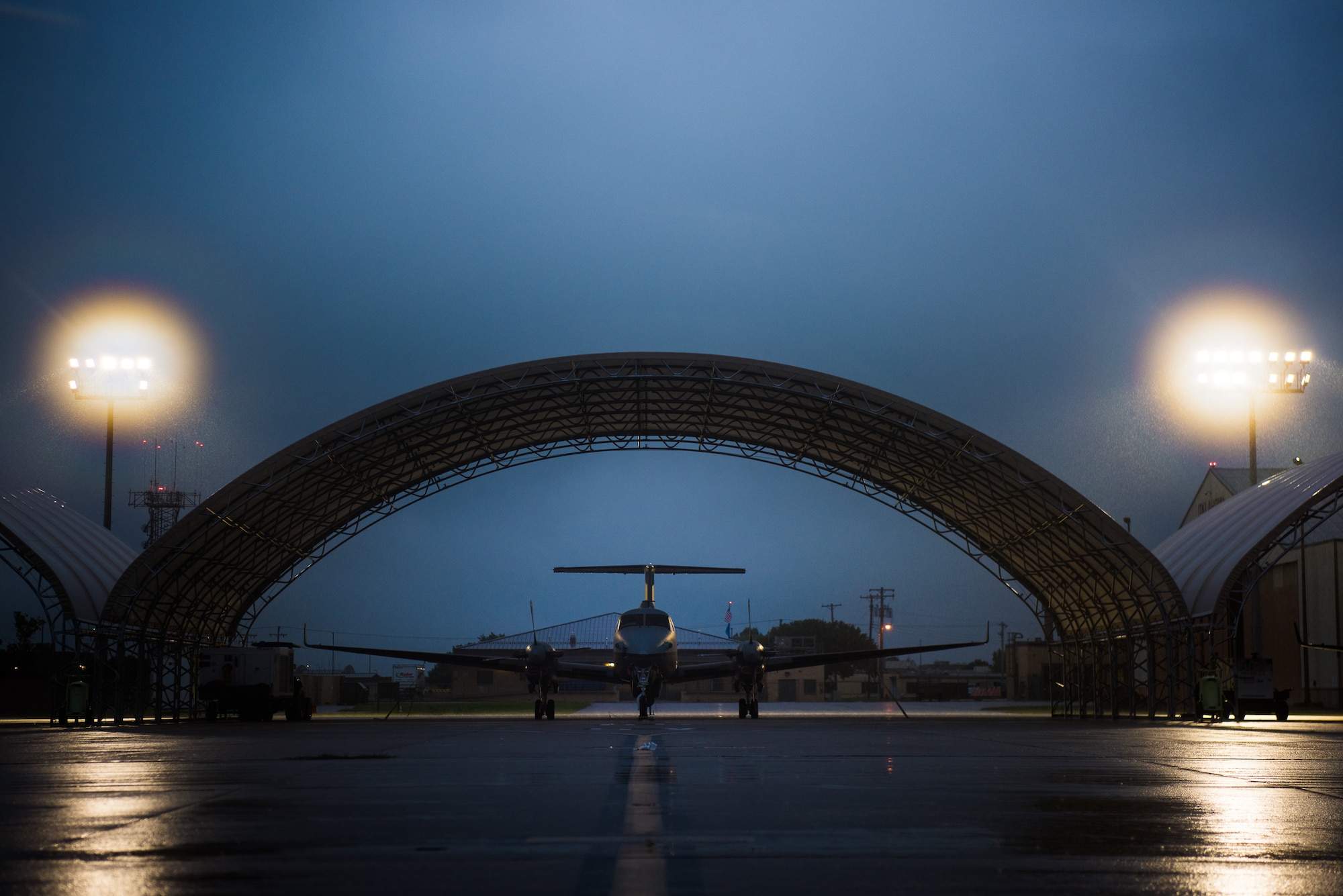 Brand new light-emitting diode, or LED, fixtures illuminate the flight line and its MC-12 Ws in an early morning downpour at Will Rogers Air National Guard Base in Oklahoma City, Sept. 7, 2018. Each pole contains 11 fixtures, which amounts to 66 fixtures on the flightline, and is part of a basewide project that replaced a total of 366 fixtures around the base. (U.S. Air National Guard Photo by Staff Sgt. Kasey M. Phipps)