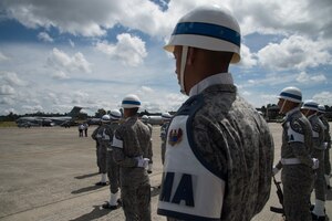 Colombian Air Force military police stand in a formation as the Colombian Air Force Chief of Staff departs Air Combat Command number 5 at Arturo Lema Posada Air Base in Rionegro, Colombia as a C-17 Globemaster III from the 14th Airlift Squadron at Joint Base Charleston, S.C., sits on the flightline Sept. 3, 2018.