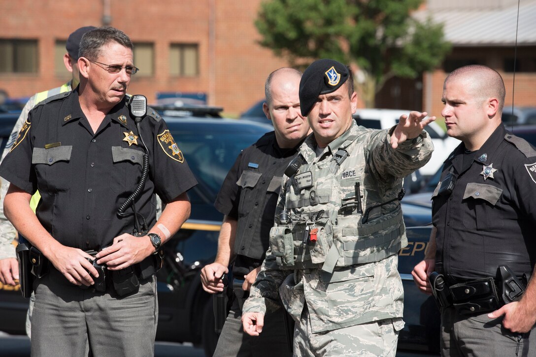 Staff Sgt. Cody McCarthy, 167th Airlift Wing security forces, briefs personnel from the Berkeley County Sheriff's Department, during an active shooter exercise at the 167th AW, Aug. 30, 2018. A lone gunman shot multiple vicitms in the base civil engineering building as part of the training scenario at the Martinsburg, W.Va. air base. Active shooter training is conducted annually at the 167th AW (U.S. Air National Guard photo by Senior Master Sgt. Emily Beightol-Deyerle)