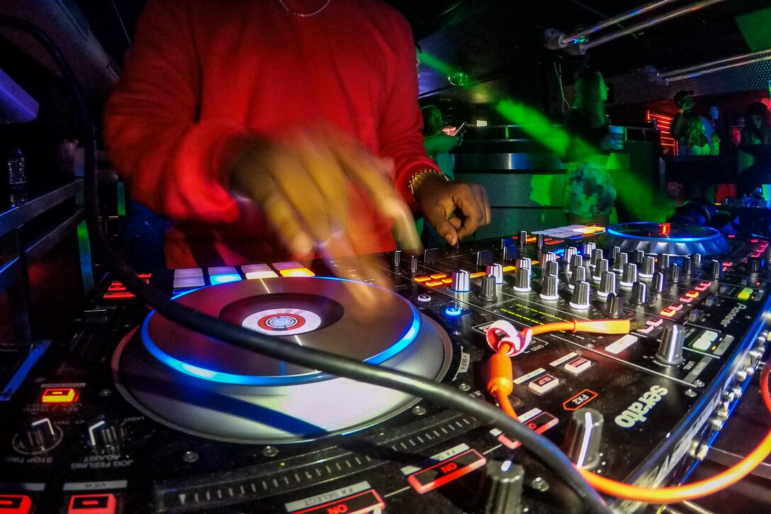 An airman spins music at a club.