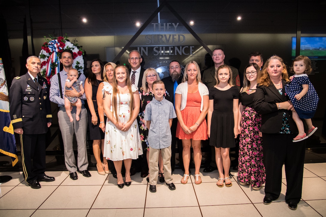 The Cavanaugh and Mitchell families stand with General Paul M. Nakasone  Director  National Security Agency in front of the Cryptologic Memorial Wall.