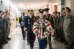 General Paul M. Nakasone  Director  National Security Agency and staff carry a wreath to the Memorial Wall.