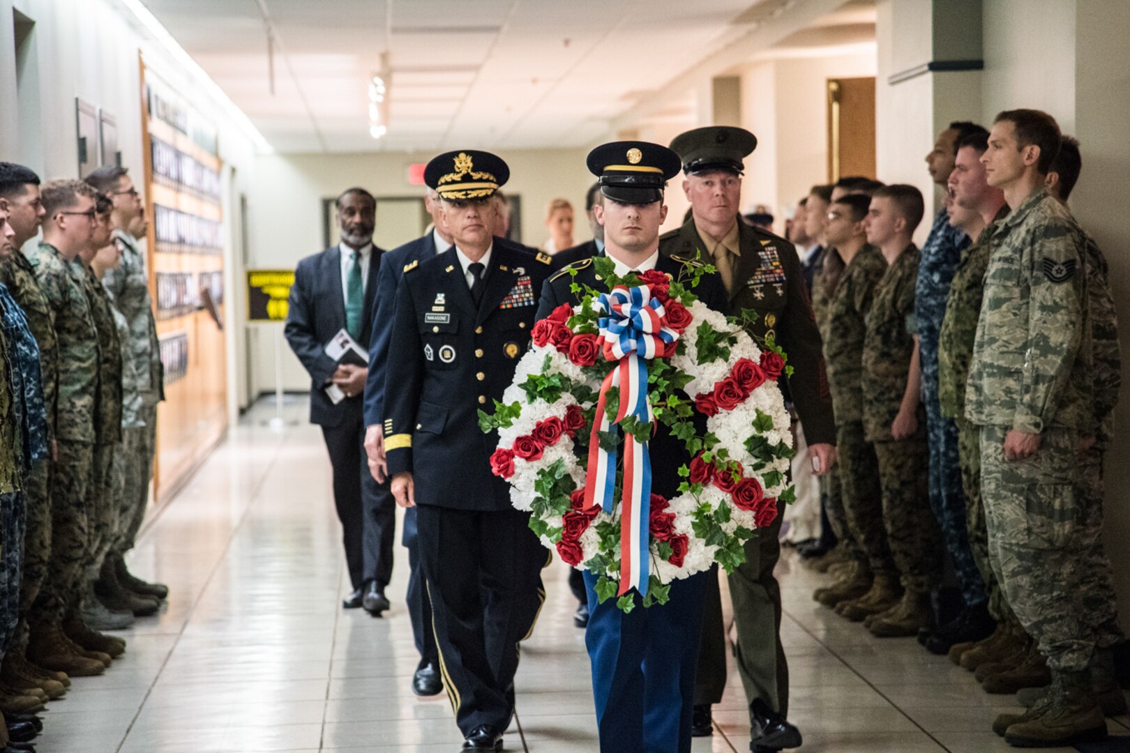 General Paul M. Nakasone  Director  National Security Agency and staff carry a wreath to the Memorial Wall.