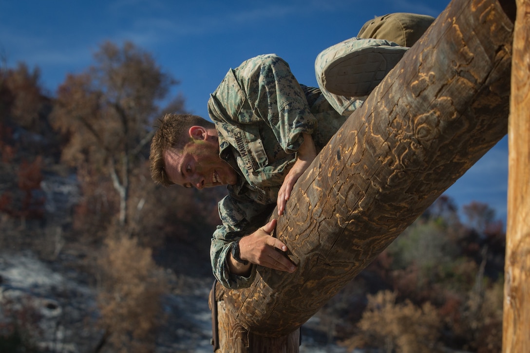 U.S. Marine Corps Lance Cpl. John Marino, a machine gunner with 1st Marine Regiment, climbs over a log during the obstacle course portion of the 1st Marine Division (MARDIV) Super Squad Competition at Marine Corps Base Camp Pendleton, California, Aug. 30, 2018.