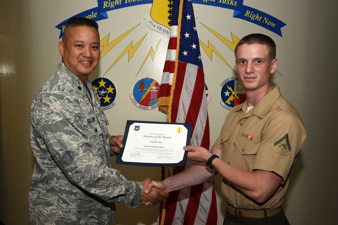 U.S. Air Force Lt. Col. Abraham Salomon, 17th Training Group deputy commander, presents the 316th Training Squadron Student of the Month award to U.S. Marine Corps Lance Cpl. Isaiah Gray, Marine Corps Detachment at Goodfellow student, at Brandenburg Hall on Goodfellow Air Force Base, Texas, Sept. 7, 2018. The 316th TRS’s mission is to conduct U.S. Air Force, U.S. Army, U.S. Marine Corps, U.S. Navy and U.S. Coast Guard cryptologic, human intelligence and military training. (U.S. Air Force photo by Staff Sgt. Joshua Edwards/Released)