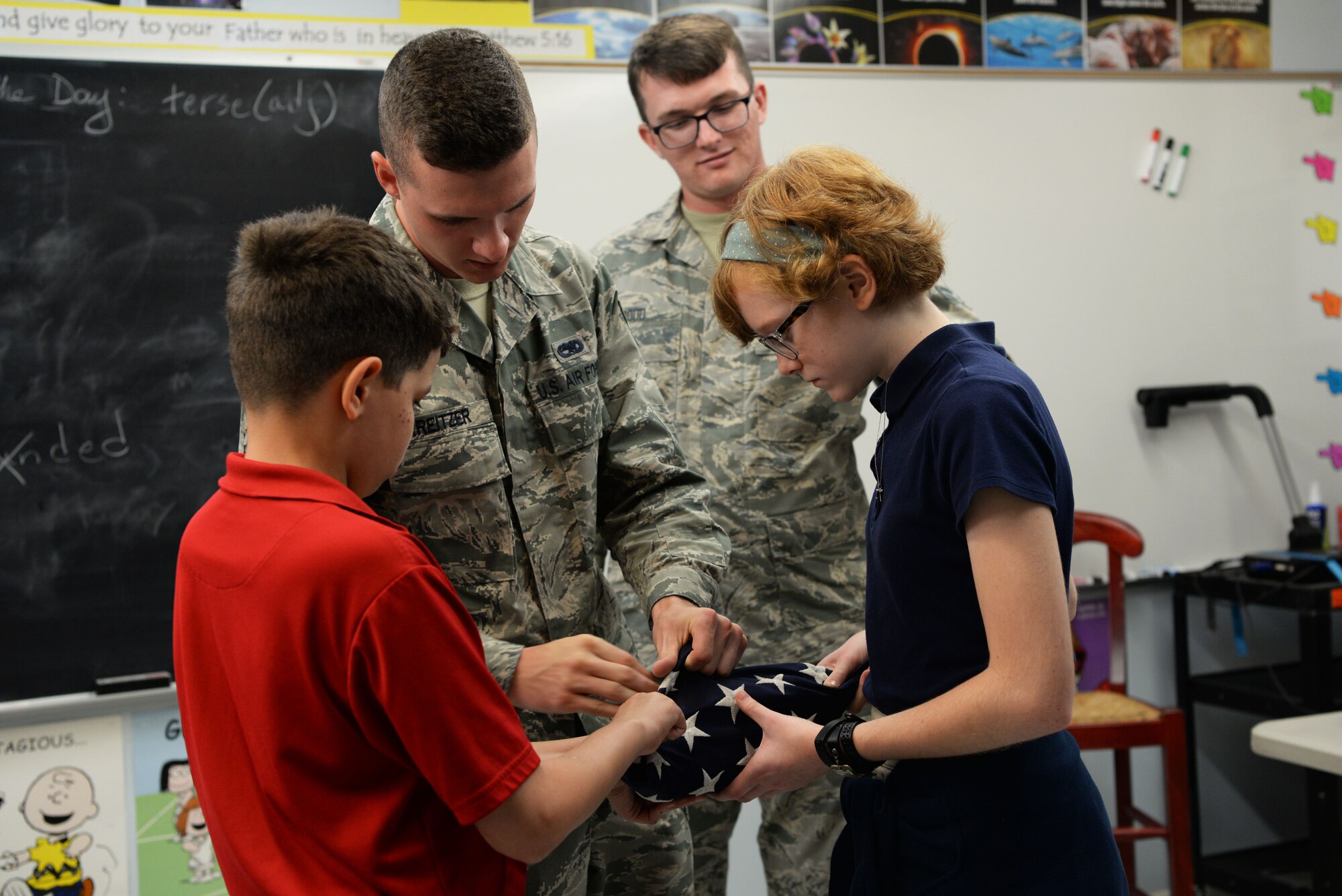 Richard Roman, seventh grade student, and Emily Ransdell, eighth grade student, practice folding the American flag Sept. 5, 2018, at St. John’s Lutheran School. The students learned the proper folding procedures of the flag and how to raise and lower it on a flagpole. (U.S. Air Force photo by Airman 1st Class Zoe M. Wockenfuss)