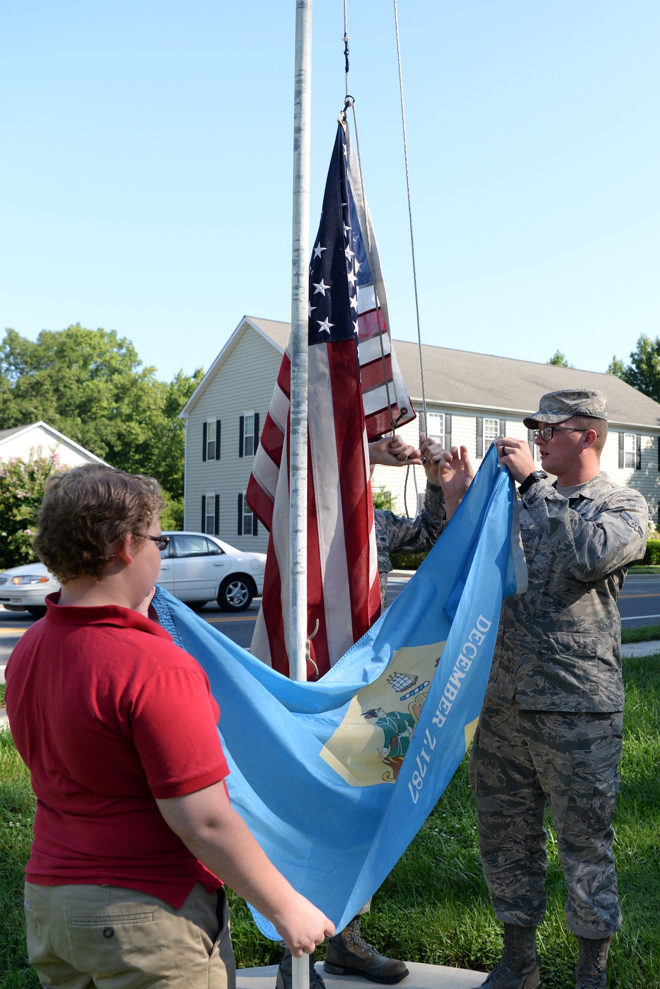 Rip Taylor, seventh grade student, and Airman 1st Class Kyle Wood, Dover Air Force Base Honor Guard member, secure the Delaware state flag Sept. 5, 2018, at St. John’s Lutheran School. The students at St. John’s learned that the American flag is always flown the highest when displayed with other flags. (U.S. Air Force photo by Airman 1st Class Zoe M. Wockenfuss)