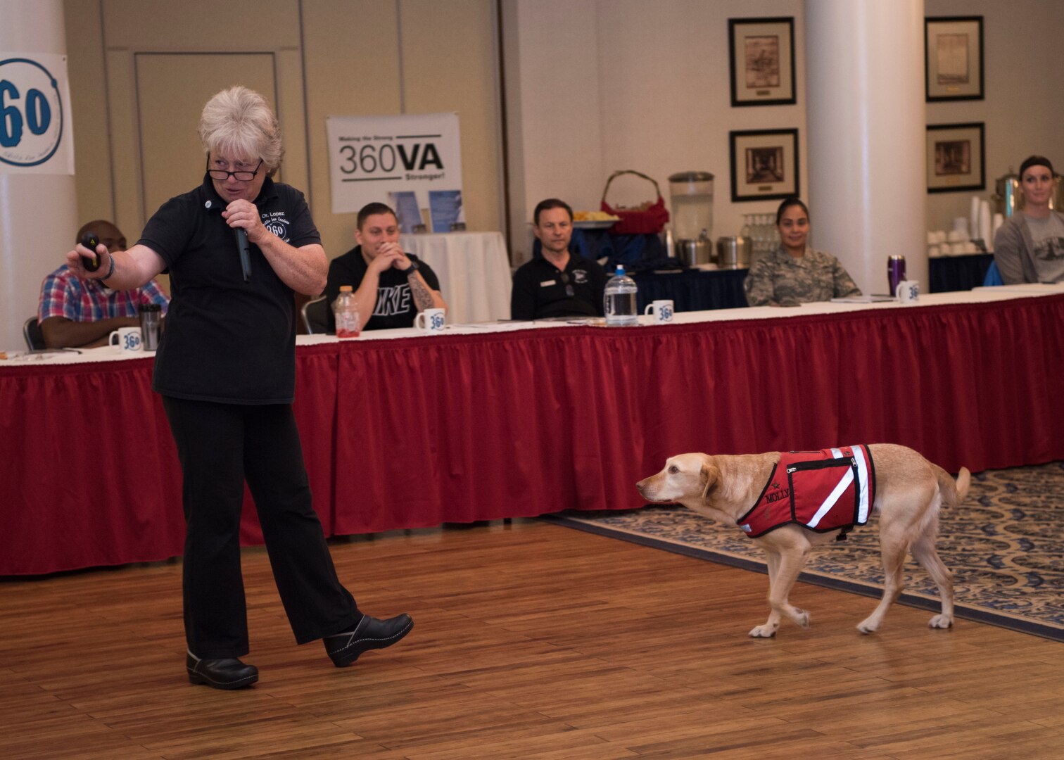 Dr. Mary Lopez, a 360° Veterans Association member, with her service dog, Molly, provides opening remarks at the 360° Leadership Course Sept. 10, 2018 at JBSA-Randolph, Texas. The 360° Leadership Course is a complex, hands-on universal leadership course focused on enhancing senior leaders while providing important and necessary tools for leaders to manage and respond to issues and challenges they may face.