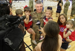 FORT KNOX, Ky. – Sgt. 1st Class Samuel Phillips, maintenance management, 1st Theater Sustainment Command, his wife and children speak to media during the White Team Redeployment Ceremony at the Sadowski Center, June 20. The team deployed to Kuwait in December and spent six-months there, traveling to various countries in the Middle East, in support of their mission. (U.S. Army photo by Mr. Brent Thacker)