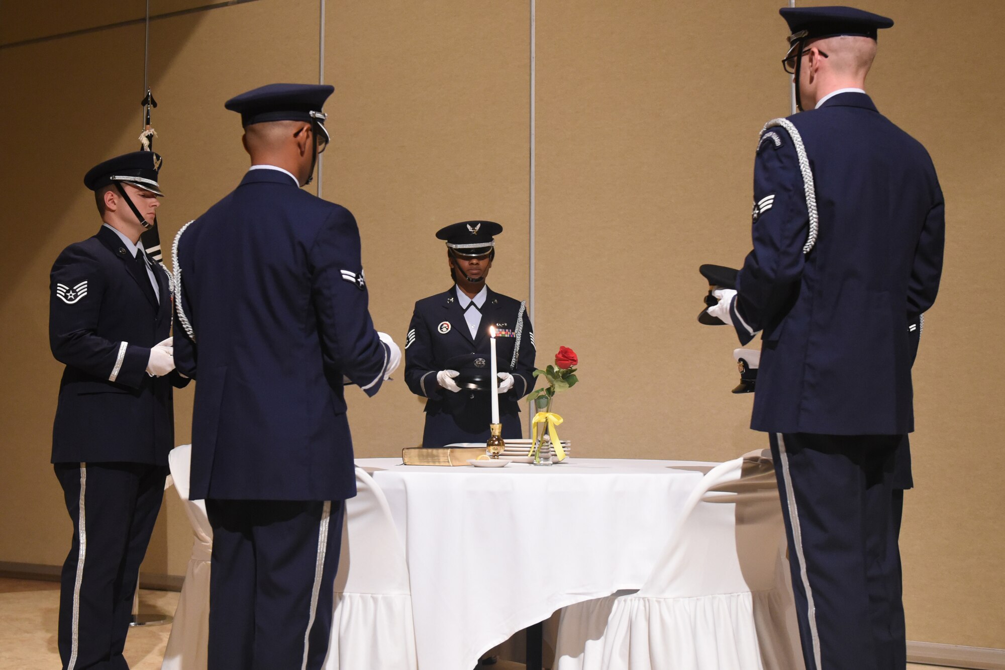 The Honor Guard sets the Prisoners of War/Missing in Action table during the Air Force Ball at the McNease Convention Center in San Angelo, Texas, Sept. 8, 2018. The table is set with symbols in remembrance of lost or missing brothers and sisters in arms. (U.S. Photos by Airman Zachary Chapman/Released)