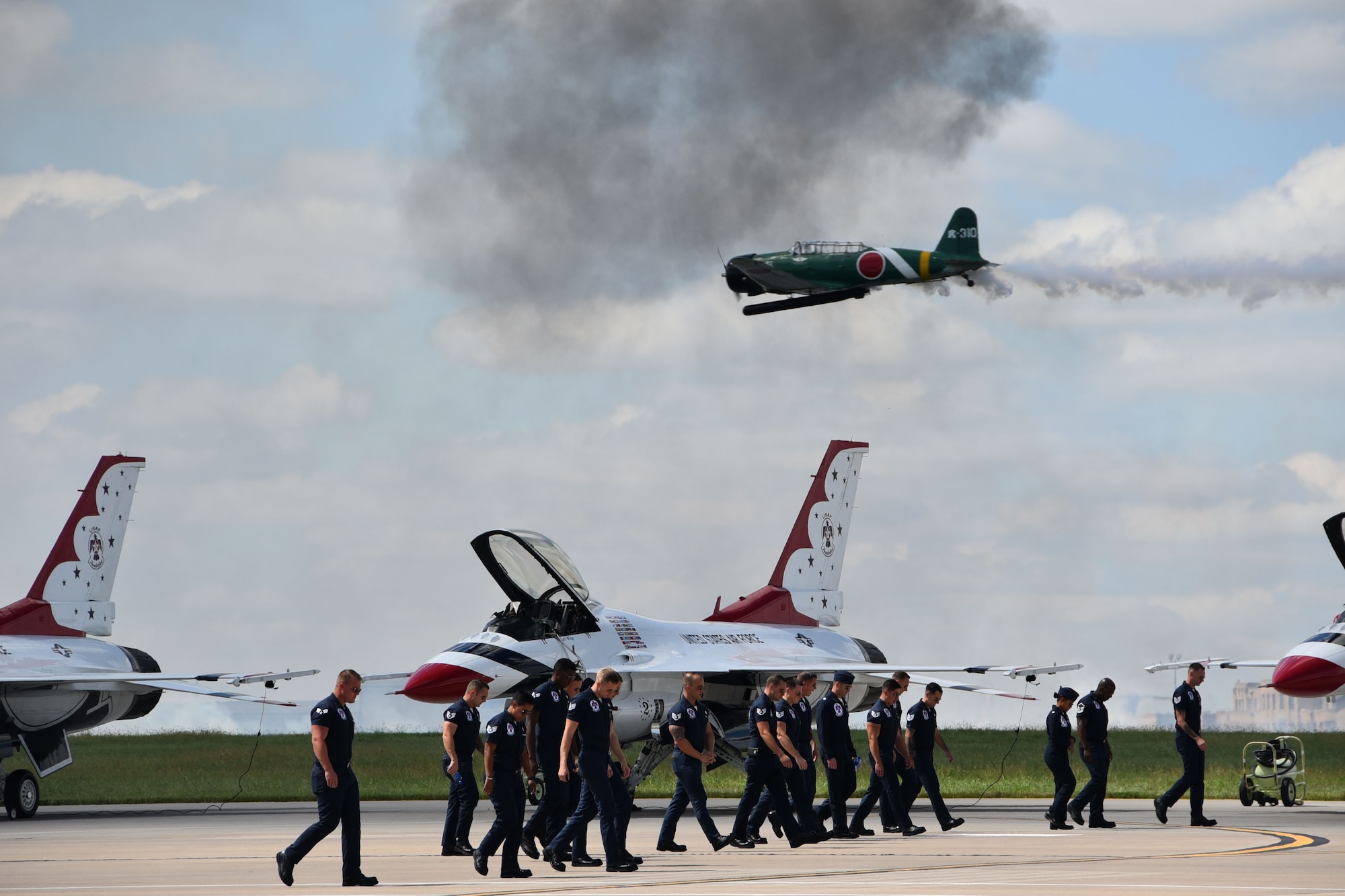 Members of he U.S. Air Force Thunderbirds Team walk across the flightline during the “Tora! Tora! Tora!” performance at the Frontiers in Flight Open House and Airshow Sept. 9, 2018, McConnell Air Force Base, Kan.  The “Tora! Tora! Tora!” Team re-enacts the attack on Pearl  (U.S. Air Force photo by Tech. Sgt. Abigail Klein)