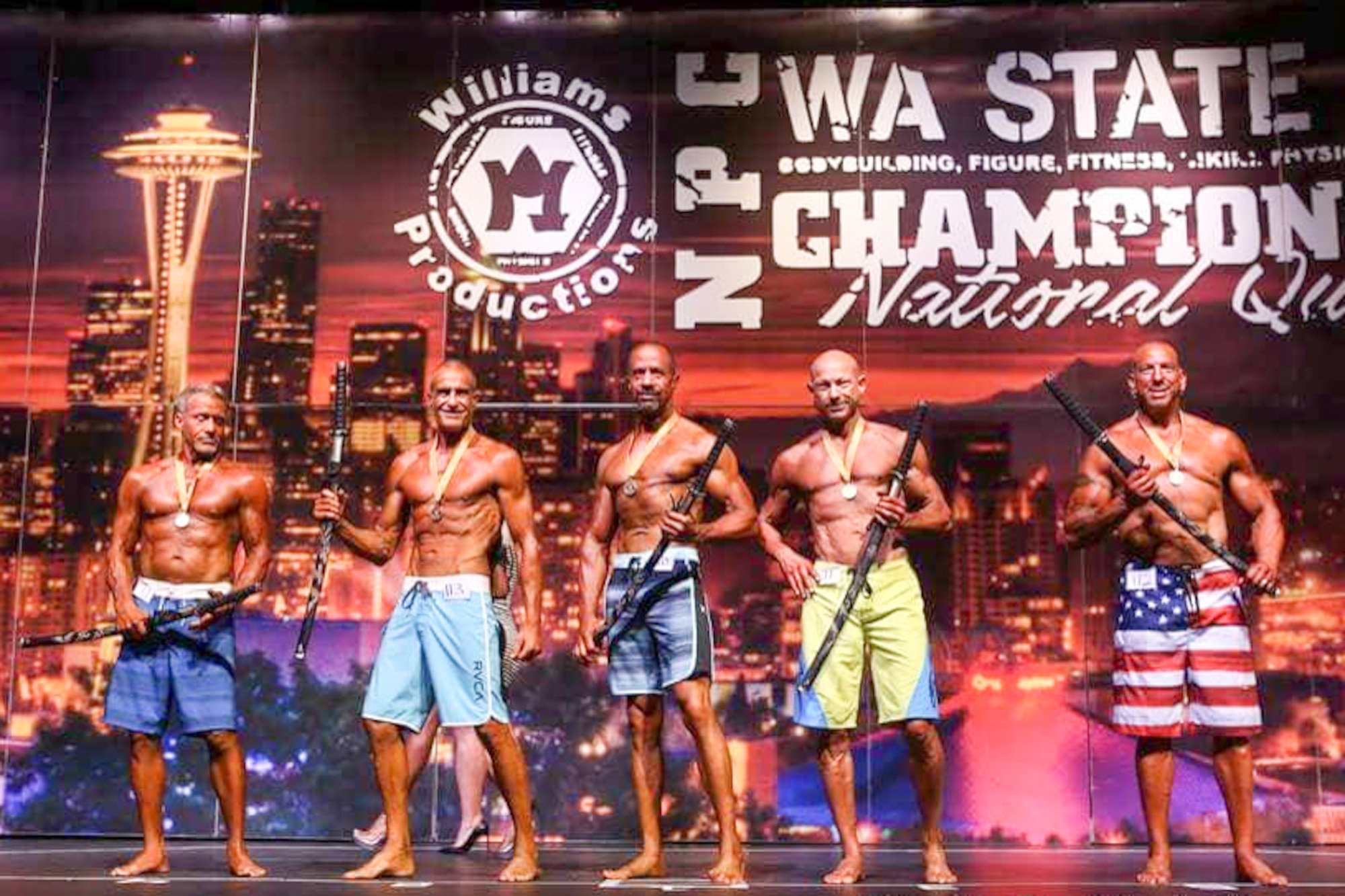 Richard Gonzales (middle), 225th Air Defense Group personnel specialist, wins first place in the Men’s Physique Masters 50 & Older class at the Washington State Championship for bodybuilding at the Auburn Performing Arts Center in Auburn, Aug. 4, 2018.