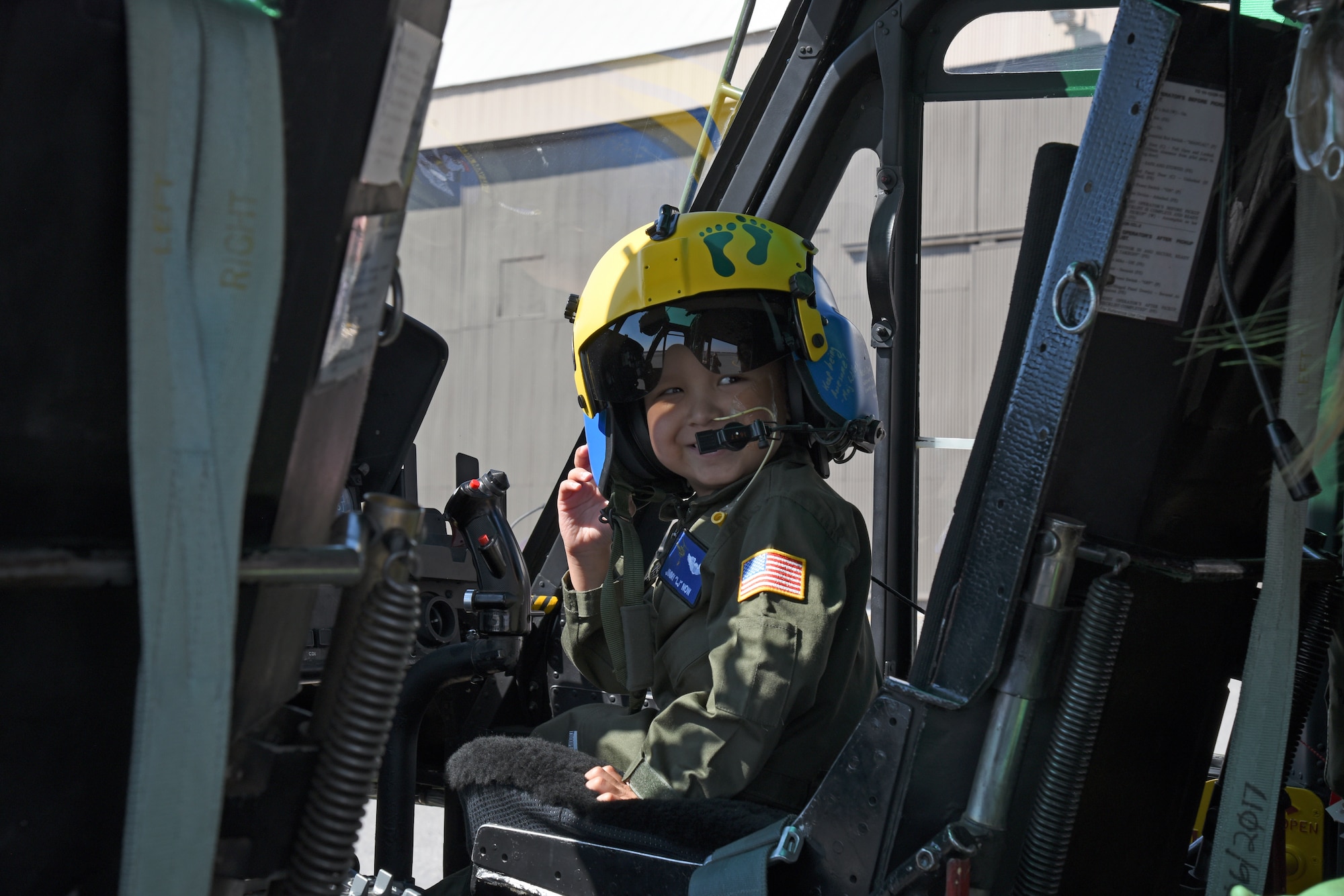 Jimmy "LJ" Now smiles at his mother, Samantha Now, as he explores a UH-1N Huey assigned to the 36th Rescue Squadron during a visit Sept. 7, 2018, at Fairchild Air Force Base, Washington. As part of his bucket list, LJ wanted to experience the life of a helicopter pilot. (U.S. Air Force photo/Staff Sgt. Mackenzie Mendez)
