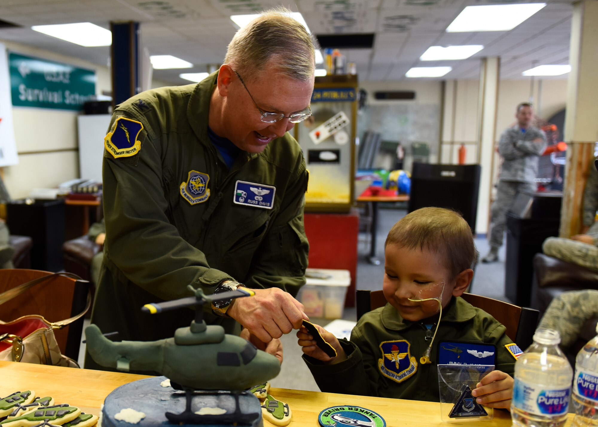 Col. Russ Davis, 92nd Operations Group commander, presents Jimmy "LJ" Now with a patch and coin during his visit to the 36th Rescue Squadron Sept. 7, 2018, at Fairchild Air Force Base, Washington. During LJ’s visit, Airmen from the 36th RQS pulled out all the stops, providing LJ with a flight suit with patches and his pilot wings, a personalized helmet and various other gifts to commemorate his time as an Honorary UH-1N Huey pilot. (U.S. Air Force photo/Airman 1st Class Lawrence Sena)