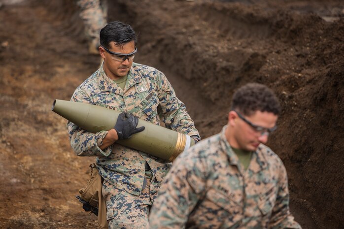 Sgt. Juan Lira, left, and Sgt. Payton S. Lawler carry 155 mm artillery rounds Sept. 3, 2018 at Camp Fuji, Japan. Explosive Ordnance Disposal Marines detonate different types of munitions with explosives during large-scale disposal. EOD Company Marines validated proficiency and prepared for worldwide mission deployment in support of III Marine Expeditionary Force by testing their ability to disable and dispose of explosives. Lira, an EOD technician, is a native of Edinburg, Texas. Lawler, an EOD technician, with EOD Company, 9th Engineer Support Battalion, 3rd Marine Logistics Group is a native of Green Bay, Wisconsin. (U.S. Marine Corps photo by Lance Cpl. Armando Elizalde)