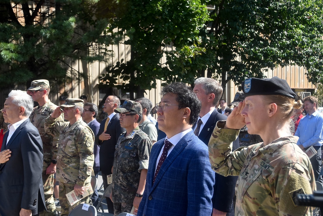 Col. Teresa Schlosser (right), U.S. Army Corps of Engineers Far East District commander, and the Honorable Seo, Yang-ho, Mayor of the Jung-gu district, honor the nation during the playing of the U.S. national anthem during a colors casing ceremony Aug. 31 to mark the closing of the district's headquarters in Seoul (Dongdaemun) and its relocation 40 miles south to Camp Humphreys.