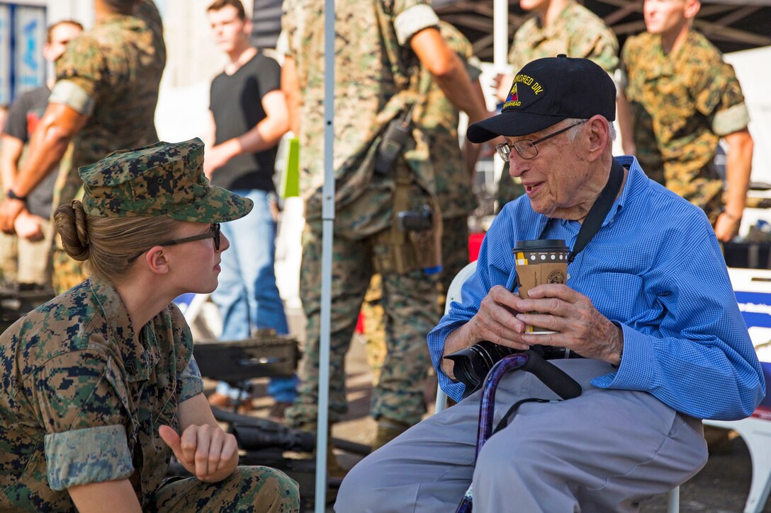 A Marine speaks with a World War II veteran.