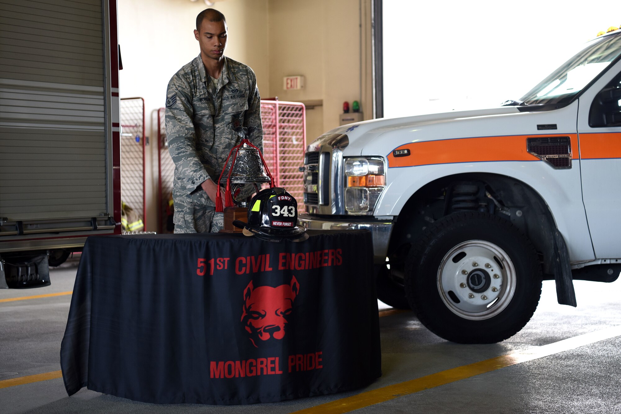 U.S. Air Force Staff Sgt. Krystopher Morgan, 51st Civil Engineer Squadron fire and emergency services flight lead firefighter, sounds a bell during a 9/11 memorial ceremony at Osan Air Base, Republic of Korea, Sept. 11, 2018. Sounding the four fives is a custom in which a bell is struck five times, in four series, to announce the death of a firefighter in the line of duty. (U.S. Air Force photo by Senior Airman Kelsey Tucker)