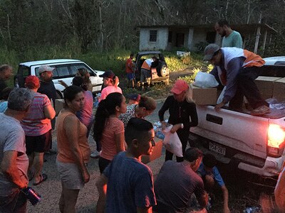 Richard Dessert, a Washington Air National Guard master sergeant, unloads emergency kits to residents in a remote mountain areas in Puerto Rico Oct. 5, 2017. On its current track, Hurricane Isaac is expected to bypass the island.