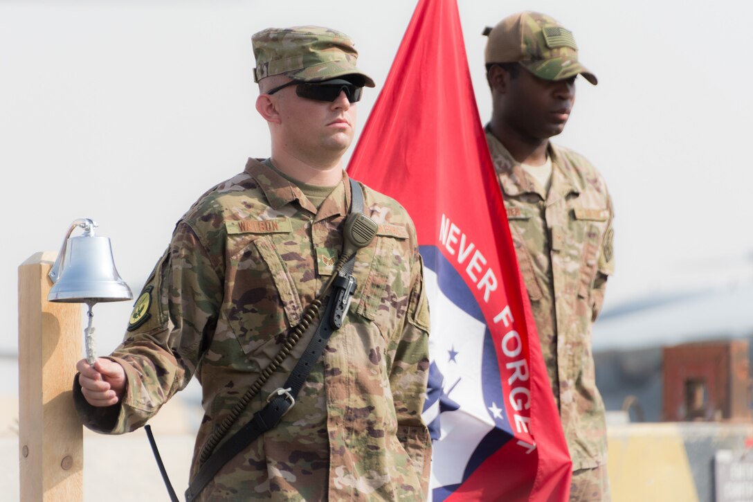 Senior Airman Adam Watson tolls a bell during a ceremony marking the 17th anniversary of the 9/11 terrorist attacks held at Al Udeid Air Base, Qatar, Sept. 11, 2018. The ceremony brought together the various emergency responder career fields represented on base to honor the sacrifices made on 9/11. (U.S. Air Force photo by Tech. Sgt. Ted Nichols/Released)