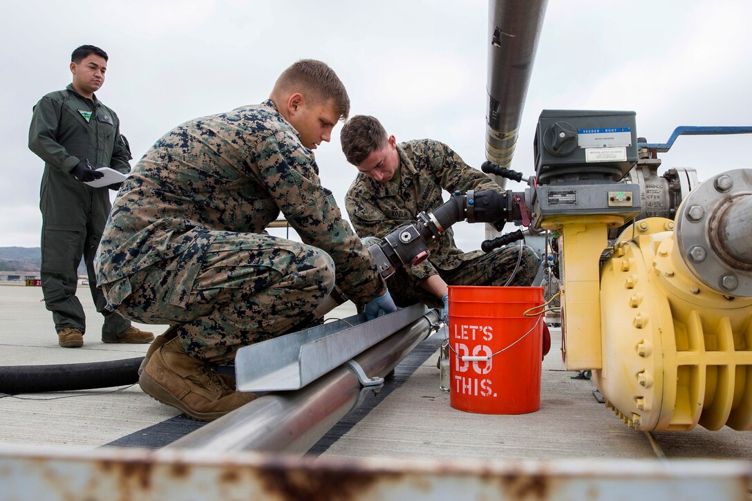 Marines takes fuel samples from a fuel pipeline.