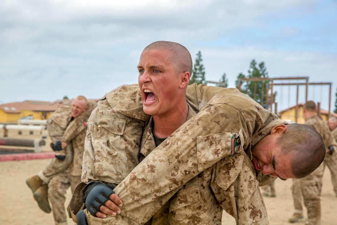 A recruit carries fellow recruit during a training exercise.