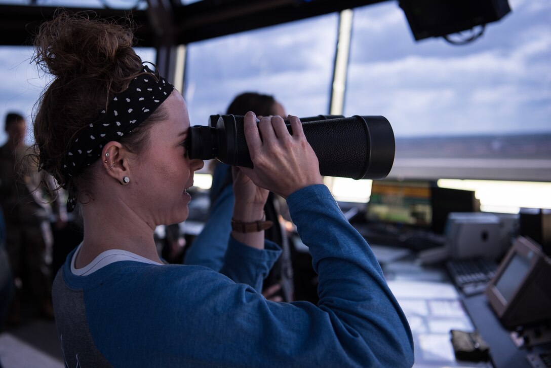 Tori Teague, Barry Elementary School principal, looks at the flightline through binoculars from the air traffic control tower at Cannon Air Force Base, N.M., Sept. 8, 2018. The Teachers Understanding Deployment Operations program brought staff members from three different school districts to Cannon AFB to show what a deployment is like. (U.S. Air Force photo by Airman 1st Class Vernon R. Walter III/Released)