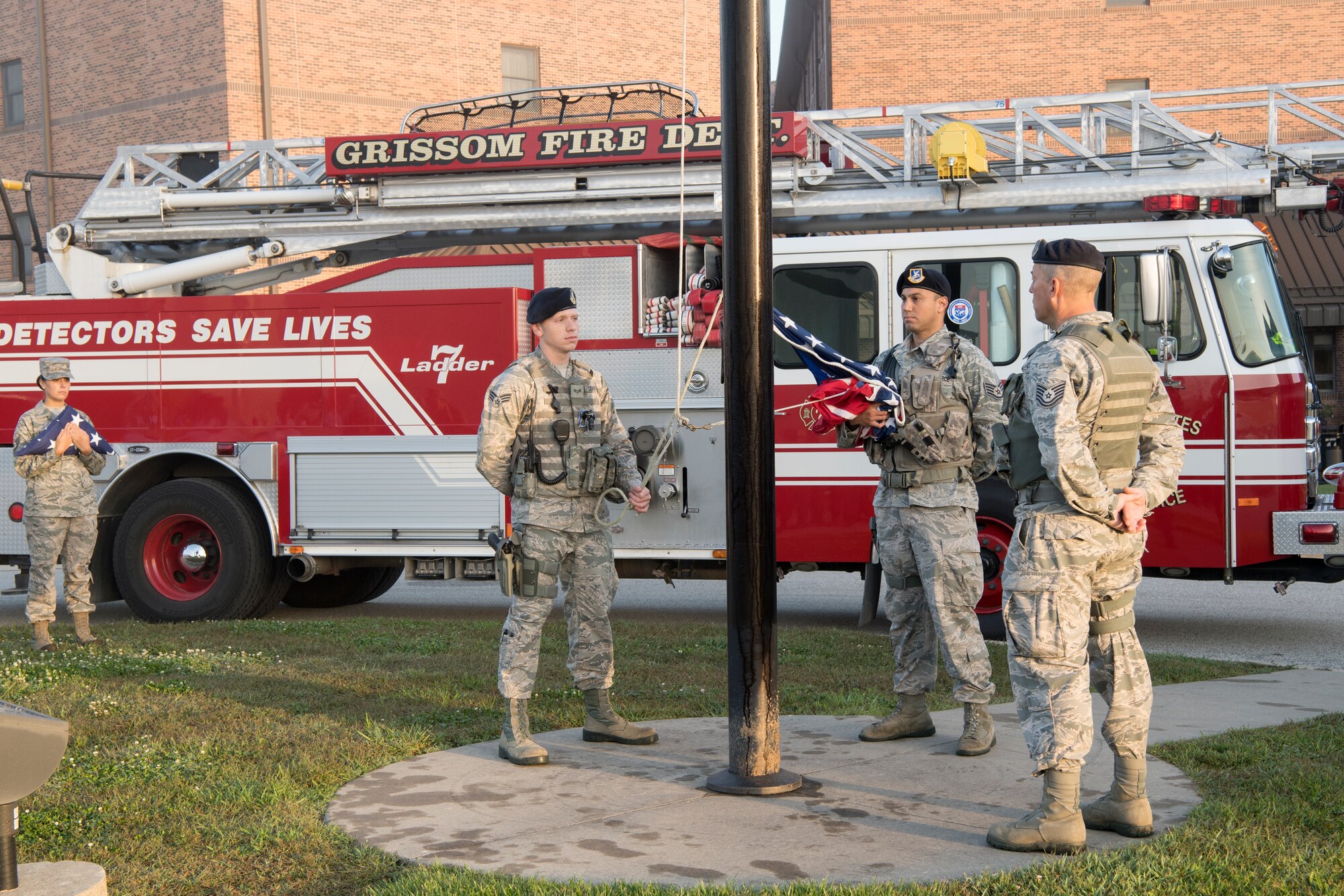 Members from the 434th Security Forces Squadron, from left to right, Senior Airman Devin Cleaver, Staff Sgt. Steve Salazar and Tech. Sgt. Tim Augustyn prepare to raise the American flag to half-staff during a 9/11 memorial ceremony at Grissom Air Reserve Base, Ind. Sept. 11, 2018. During the ceremony, more than 50 firemen, police, Airmen, NCOs, Officers, and civilians came together to pay their respects. (U.S. Air Force Photo/Tech. Sgt. Benjamin Mota)