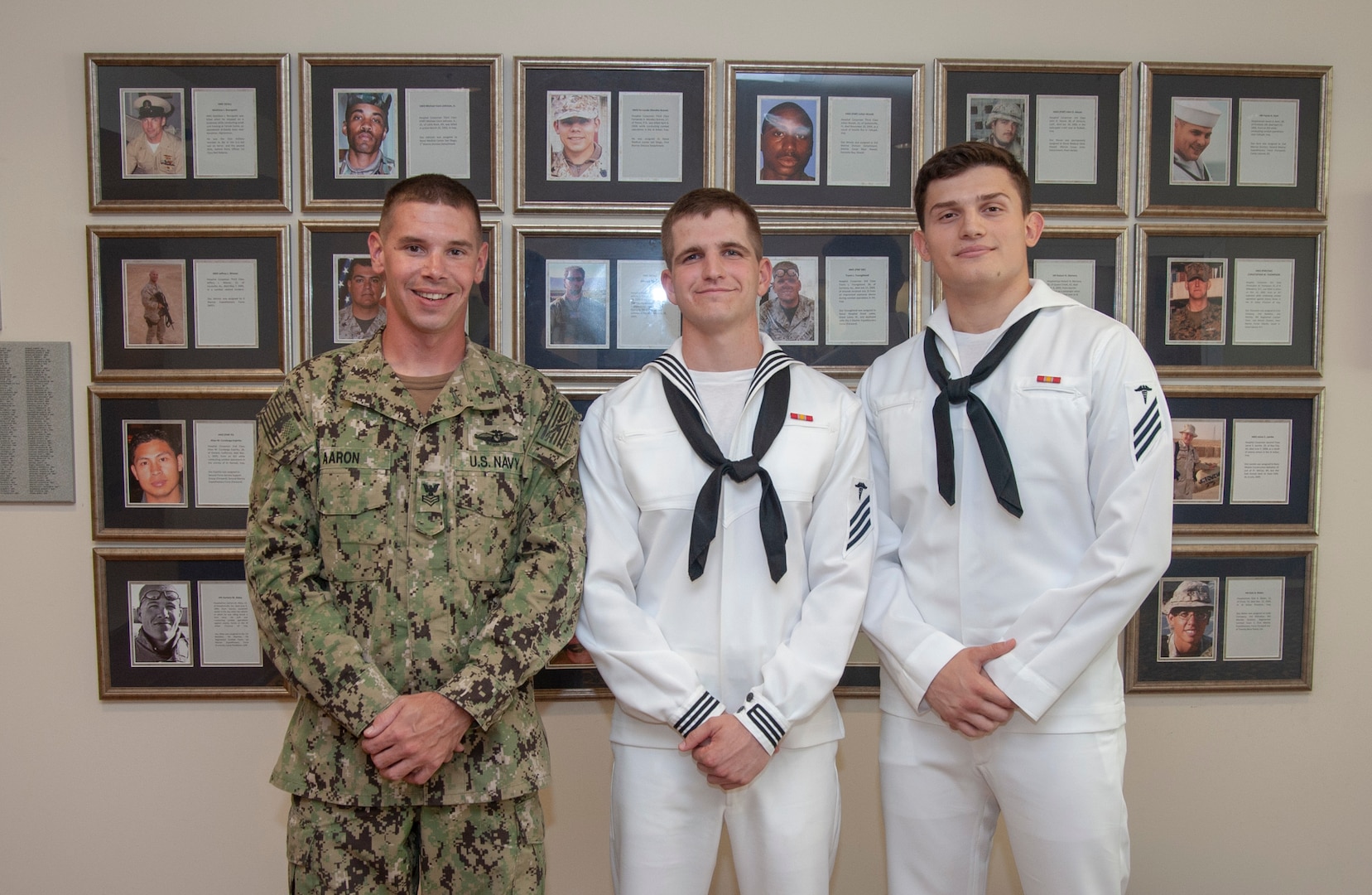 Seaman Nicholas Earls (left), Seaman 1st Class Michael Aaron (center), an instructor with the Hospital Corpsman Basic (HCB) program, and Seaman Enea Preci (right), pose for a photo at the Medical Education and Training Campus. The three Sailors acted as first responders, assisting a patient who collapsed at the Veterans Affairs Emergency Room Aug. 27.