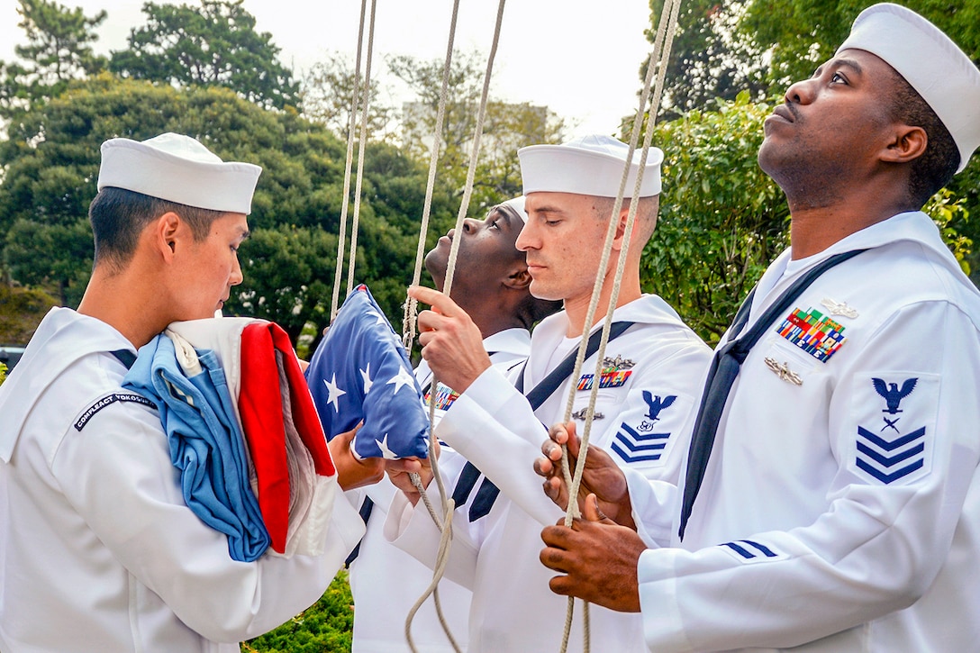 Sailors unfold flags.