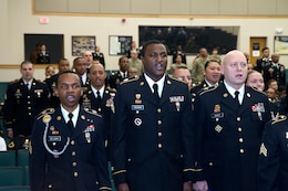 From left to right, Sgt. Nahjier Williams, a broadcast journalist with 1st Theater Sustainment Command Public Affairs, Sgt. Carlos Vaughn, G-6, 1st TSC, and Sgt. Andy Scott, material control accounting noncomissioned officer, support operations (SPO), 1st TSC, recite the NCO creed during the 1st TSC NCO induction ceremony March 2, 2018 at Fort Knox, Ky.