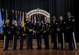 FORT KNOX, Ky. – The newest noncommissioned (NCO) inductees from the 1st Theater Sustainment Command (TSC) stand together for a group photo with Command Sgt. Major Jason Willett, senior enlisted advisor, 1st TSC, center left and keynote speaker, Sgt. Maj. Edward Bell, deputy chief of staff, G-4, center right, during the 2018 NCO Symposium, Aug 28-30, at the Gen. George Patton Museum. The symposium allowed for professional open-forum discussion amongst the NCO ranks. (U.S. Army photo by Spc. Zoran Raduka)