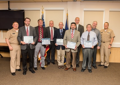 PANAMA CITY, Florida - The Naval Surface Warfare Center Panama City Division (NSWC PCD) Advanced Naval Technology Exercise (ANTX) team is presented the Naval Sea Systems Command Warfare Centers Collaboration Award by Commander, NSWC Rear Adm. Tom Anderson, USN, Sept. 6, 2018. Pictured from left to right: NSWC PCD Commanding Officer Capt. Aaron. Peters, Jason Fraioli, Russell Shepherd, NSWC PCD Technical Director Ed Stewart (SES), Christopher Velkey, Fredric Strynar, Daniel Kucik, John Allen, Donald McCall, and Commander, NSWC Rear Adm. Tom Anderson. U.S. Navy photo by Anthony Powers